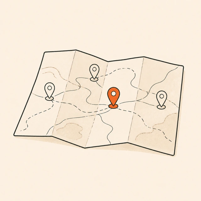 A folded paper map with four location pins along the routes; the middle pin is orange.